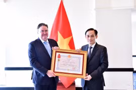 El ministro de Relaciones Exteriores, Le Hoai Trung (derecha), entrega la Orden de Amistad al embajador estadounidense Marc Evans Knapper (Foto: VNA)