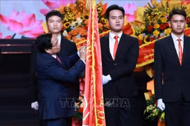 El primer ministro Pham Minh Chinh coloca la Orden Ho Chi Minh en la bandera tradicional de la VOV (Foto: VNA)