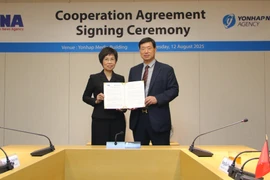 La directora general de la VNA, Vu Viet Trang, y el presidente de Yonhap, Hwang Dae-il, anuncian el acuerdo firmado entre ambas agencias (Foto: VNA)