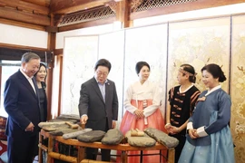 El secretario general del PCV, To Lam, y su cónyuge, Ngo Phuong Ly, presentan sobre el xilófono de piedra de Vietnam al presidente surcoreano Lee Jae Myung y su esposa, Kim Hae Kyung (Foto: VNA)