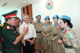 El viceministro vietnamita de Defensa, coronel general Hoang Xuan Chien, y el subsecretario de Defensa de Australia, Hugh Jeffrey, intercambian con las mujeres oficiales (Foto: VNA)
