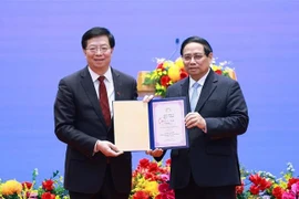 Qiu Yong (izquierda), secretario del Comité del Partido Comunista de China en la Universidad de Tsinghua, entrega el título de "Profesor Honorario" al primer ministro Pham Minh Chinh. (Foto: VNA)