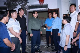 El primer ministro Pham Minh Chinh (centro) visita la comuna de Quy Nhat para inspeccionar y dirigir las labores de recuperación tras el tifón Bualoi. (Foto: VNA)