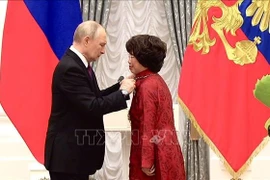 Thai Huong, presidenta del Consejo de Estrategia del gigante lácteo vietnamita TH Group, recibe la Orden de la Amistad de manos del presidente ruso, Vladimir Putin. (Foto: VNA)