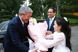 El primer ministro de Kirguistán, Adylbek Kasimalyev, recibe flores en la ceremonia de bienvenida. (Foto: VNA)