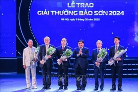 El viceprimer ministro Nguyen Chi Dung entrega flores para felicitar a los ganadores. (Foto: VNA)