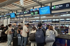 Los pasajeros realizan el check-in en el mostrador de Vietnam Airlines en el Aeropuerto Internacional de Kuala Lumpur. (Foto: VNA)