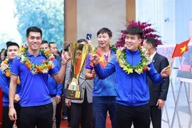 El capitán Do Duy Manh (al frente, a la derecha) y Nguyen Tien Linh llevan el trofeo a la reunión con el primer ministro Pham Minh Chinh. (Foto: VNA)