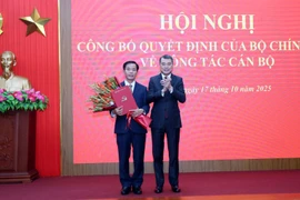 El miembro del Buró Político, secretario del Comité Central del PCV y jefe de su Comisión de Organización, Le Minh Hung (derecha), entrega la decisión a Nguyen Van Phuong (Foto: VNA)