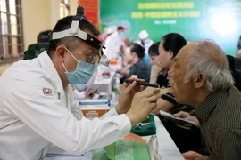 Un médico militar chino realiza chequeo a un poblador de la provincia de Lang Son (Foto: VNA)