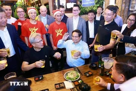 El primer ministro de Vietnam, Pham Minh Chinh, y el director ejecutivo de NVIDIA, Jensen Huang, disfrutan de la comida callejera de Hanoi el 5 de diciembre de 2024. (Foto: VNA)