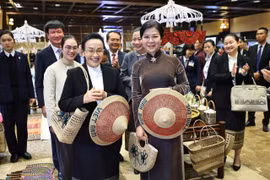 Ngo Phuong Ly (derecha), esposa del secretario general del Partido Comunista de Vietnam, y Naly Sisoulith, esposa del secretario general del Partido Popular Revolucionario de Laos y presidente del país, participan en un intercambio con destacados artesanos de varias aldeas de oficios tradicionales de la provincia de Ninh Binh. (Foto: VNA)