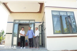 Una familia se muda a su nueva casa construida gracias al apoyo de financiación de benefactores. (Foto: VNA)