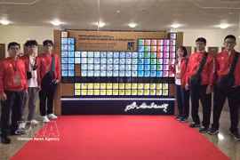 La delegación vietnamita posa para una foto junto a la tabla periódica de Mendeleev antes de la ceremonia de inauguración. (Foto: VNA)