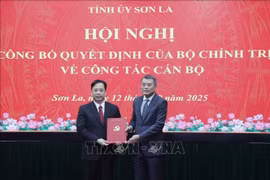 Le Minh Hung (der.), miembro del Buró Político, secretario del Comité Central del Partido y jefe de su Comisión de Organización, presenta la decisión de nombramiento a Hoang Van Nghiem. (Foto: VNA)