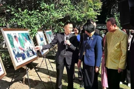 Pham Anh Tuan, director general de la Autoridad del Servicio de Información Exterior del Ministerio de Información y Comunicación (izquierda) y visitantes de la exposición de Bangkok sobre la cultura, la gente y los paisajes de Vietnam. (Foto: VNA)