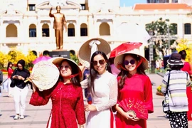 Vietnamitas que regresan del exterior exploran la calle de flores de Nguyen Hue. (Foto: qdnd.vn)