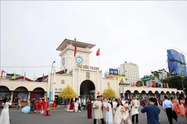 Turistas posan para fotos frente al mercado Ben Thanh, en Ciudad Ho Chi Minh. (Foto: VNA)