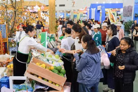 Muchas personas visitan al puesto de exhibición de productos típicos de la provincia de Son La (Foto: VNA)