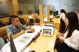 Clientes realizan transacciones en el banco Agribank (Foto: https://hanoimoi.vn/)