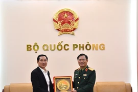 El jefe del Estado Mayor General del Ejército Popular de Vietnam y viceministro de Defensa, general Nguyen Tan Cuong, entrega un obsequio al coronel general Saichay Kommasith, viceministro de Defensa y jefe del Estado Mayor General del Ejército Popular de Laos. (Foto: qdnd.vn)