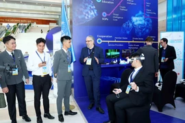 Delegados visitan el espacio de exhibición de tecnología de las Naciones Unidas durante la ceremonia de firma de la Convención de Hanoi. (Foto: VNA)