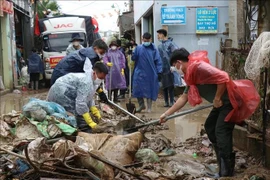 Las fuerzas armadas ayudan a los pobladores a limpiar las calles (Foto: VNA)