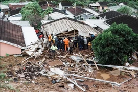 Búsqueda de víctimas atrapadas bajo una casa derrumbada tras las inundaciones en la ciudad de Durban, provincia de KwaZulu-Natal, Sudáfrica, el 12 de abril de 2022. (Foto: AFP/VNA)