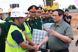 El primer ministro Pham Minh Chinh (derecha) se reúne con las unidades encargadas de la construcción de la terminal T2 del Aeropuerto Dong Hoi (Foto: VNA)