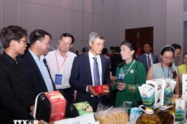 El embajador de Hanoi en Phnom Penh, Nguyen Minh Vu, y empresarios camboyanos visitan el stand vietnamita. (Foto: VNA)
