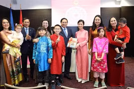 El primer ministro Pham Minh Chinh y su esposa otorgan libros en idioma vietnamita a la comunidad de residentes vietnamitas en Estonia. (Foto: VNA)