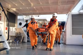 Trasladan a un paciente extranjero a tierra para recibir tratamiento médico. (Foto: VNA)