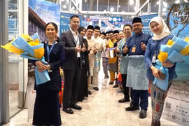 Representantes de Vietnam Airlines, Departamento General de Turismo de Malasia y el Aeropuerto Internacional de Kuala Lumpur esperan para recibir a los primeros pasajeros del vuelo Hanoi-Kuala Lumpur en la noche del 1 de abril de 2025. (Fuente: VNA)
