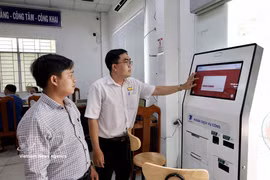 Funcionarios del Centro de Servicios Administrativos Públicos del barrio de Long Xuyen (provincia de An Giang) orientan a los ciudadanos sobre cómo realizar trámites en línea a través del Portal Nacional de Servicios Públicos. (Foto: VNA)