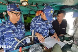 Oficiales y soldados de la Guardia Costera Región 2 realizan la divulgación a los pescadores sobre el cumplimiento de las normas en la lucha contra la pesca IUU. (Foto: VNA)