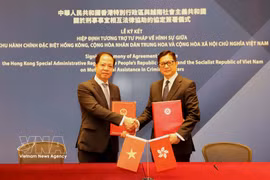 El vicepresidente de la Fiscalía Suprema Popular de Vietnam, Tran Hai Quan, y el director del Departamento de Seguridad de Hong Kong, Tang Ping Keung, en la firma. (Fuente: VNA)
