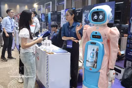 Visitantes estudian un modelo de robot diseñado para el cuidado de personas mayores en el stand de Qualcomm. (Foto: VNA)