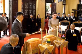 El rey de Tailandia, Maha Vajiralongkorn, y la reina Suthida Bajrasudhabimalalakshana llevan a cabo una ceremonia de encendido de velas para orar por la paz y el bienestar en la pagoda Quan Su. (Fuente: VNA)