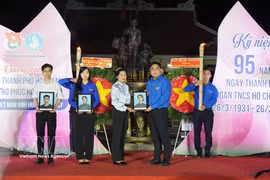 Ngo Minh Hai, secretario de la Unión de Jóvenes de Ciudad Ho Chi Minh y presidente de la Unión de Jóvenes de Vietnam en Ciudad Ho Chi Minh, entrega retratos a la familia de la Heroica Madre Vietnamita Nguyen Thi Dau y sus dos hijos, los mártires Tran Thi Sau y Tran Van Chan. (Foto: VNA)