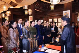 Las primeras damas escuchan una presentación sobre el arte de la caligrafía vietnamita. (Foto: VNA)