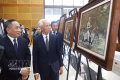 Khamphan Pheuiyavong, jefe del Departamento Central de Propaganda de Laos, y otros delegados visitan la exposición. (Foto: VNA)