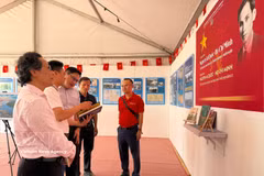 Representantes del periódico Nhan Dan presentan la exposición sobre el presidente Ho Chi Minh y la lucha de Vietnam por la independencia al embajador de Laos en Francia, Kalamoungkhoune Souphanouvong (en el centro). (Foto: VNA)