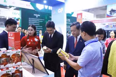 El embajador de Vietnam en Laos, Nguyen Minh Tam y el viceministro de Industria y Comercio de Laos, Phouthavanh Nanthavong visitan un stand vietnamita en la feria (Foto: VNA)