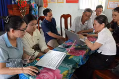 Miembros del equipo comunitario de tecnología digital de la aldea Phuong Quy 2, comuna de Ngok Bay, guían a los residentes en la presentación de trámites administrativos en línea. (Foto: VNA)