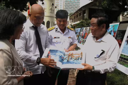 El fotógrafo Nguyen A presenta el libro "Historias sobre el mar e islas de la Patria" a los visitantes de la exposición. (Fuente: VNA)