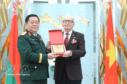 El general Nguyen Trong Nghia, miembro del Buró Político, secretario del Comité Central del Partido Comunista de Vietnam, miembro del Buró Ejecutivo de la Comisión Militar Central y director del Departamento General de Política del Ejército Popular de Vietnam, entrega un obsequio conmemorativo a Vasili Ivánovich Braga, presidente de la Asociación de Expertos Militares Bielorrusos que prestaron asistencia a Vietnam. (Fuente: VNA)