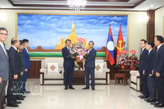El embajador Nguyen Minh Tam entrega las flores del secretario general del Partido, To Lam, a la Comisión de Relaciones Exteriores del Comité Central del PPRL para felicitar al partido por su 71.º aniversario de fundación. (Foto: VNA)