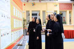 Monjes de la Congregación de las Hermanas de la Caridad de la Santa Cruz consultan la lista de candidatos en el colegio electoral No. 1, barrio de Hoan Kiem, Hanoi. Foto: VNA