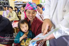 La alumna Hang Thi Cha lee siguiendo las indicaciones del maestro en el libro de texto de idioma vietnamita de primer grado. (Foto: VNA)
