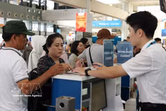 Pasajeros realiza procedimientos en aeropuerto internacional de Noi Bai en Hanoi. (Foto: VNA)